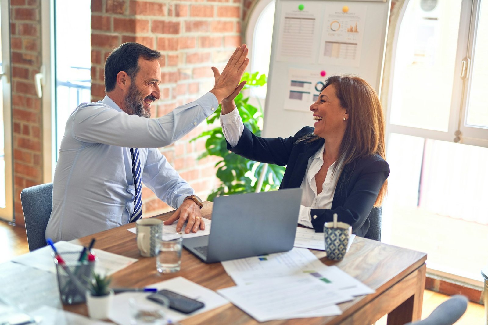 Two colleagues celebrating a successful outcome together over their work